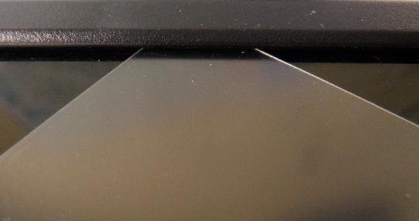 De SmartFolie Clickfolie klemt onder de opstaande rand van de laptop of monitor.